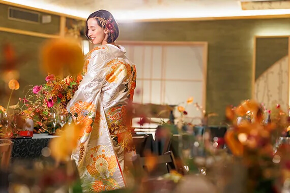 屏風絵を背景に立つ和装の新婦